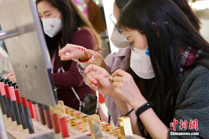 圖為女生正在體驗口紅產(chǎn)品。 殷立勤 攝