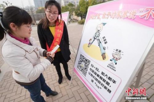 資料圖：今年3月8日，安徽合肥新華社區(qū)志愿者夏一瓊(右)向市民普及反家暴相關(guān)法律知識。鐘欣 攝